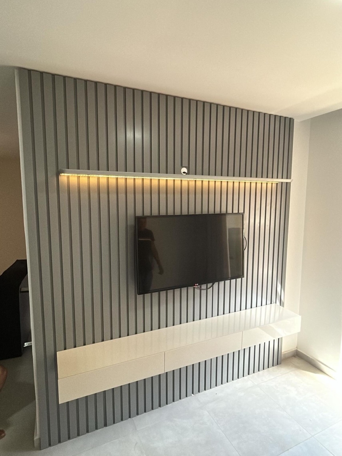 Painel ripado cinza com TV instalada