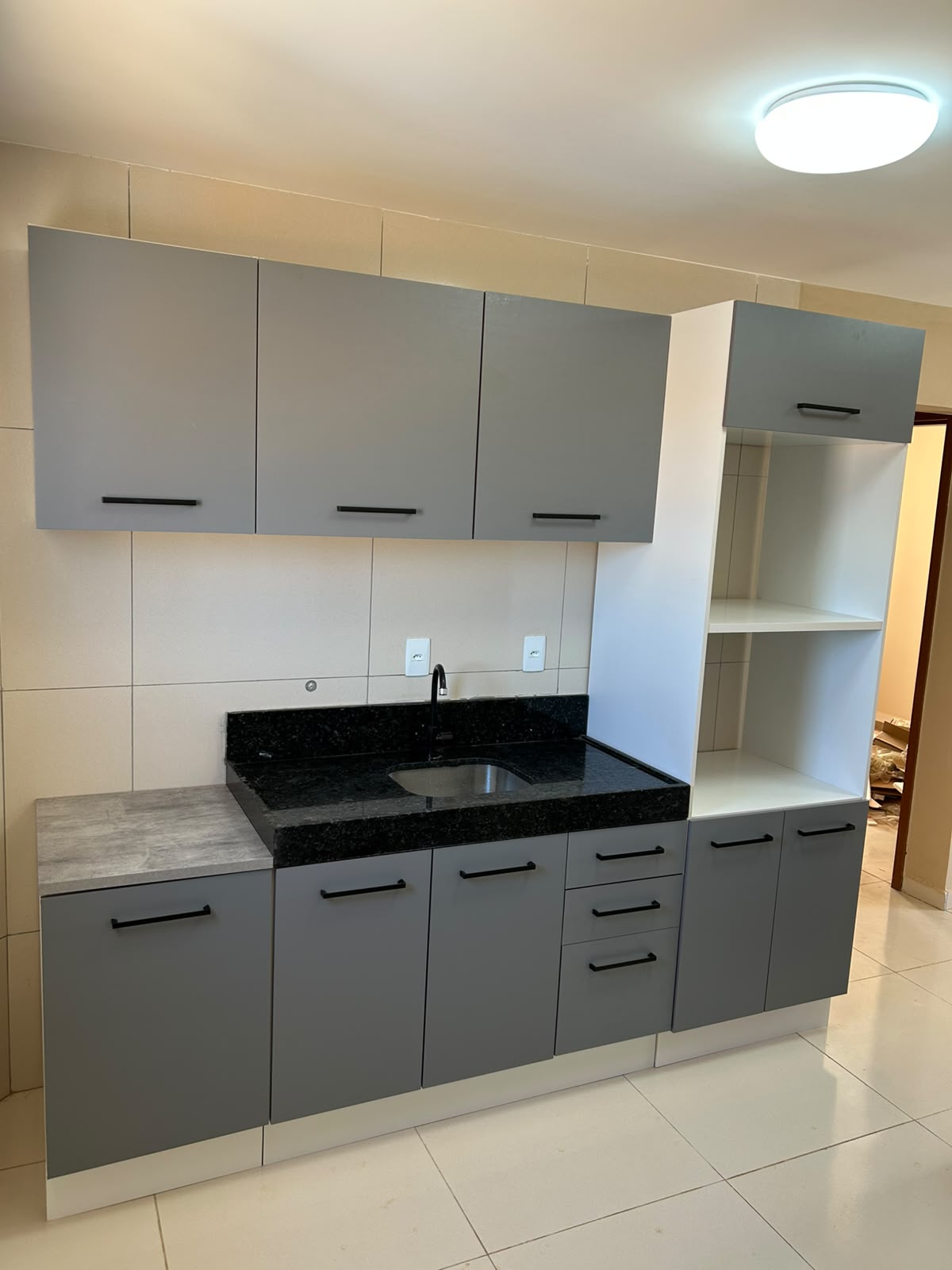 Cozinha planejada cinza com bancada preta